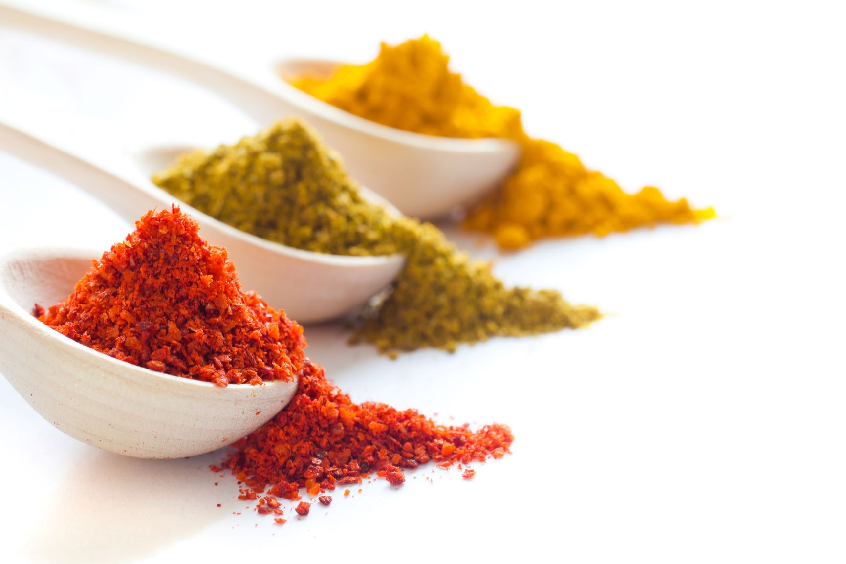 Supercharge your metabolism Crushed spices in three wooden spoons close up