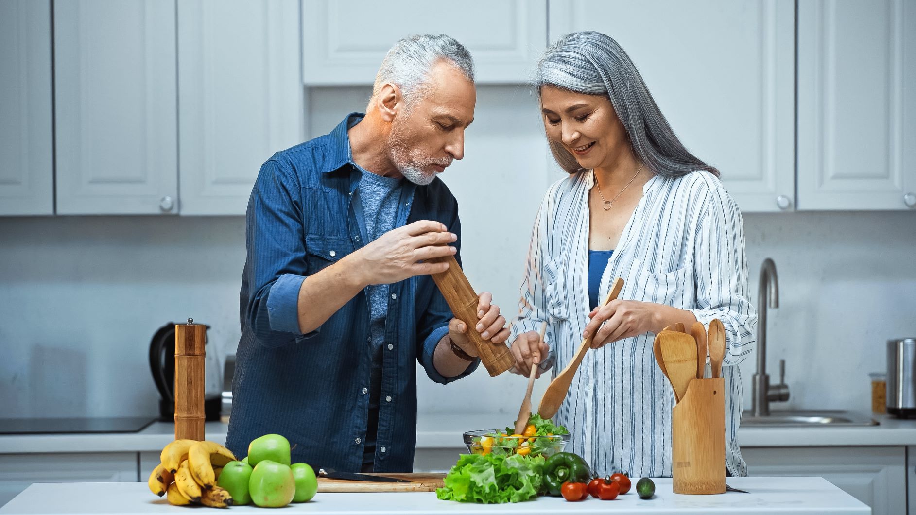 Middle-aged couple adding pepper to salad, best spices for metabolism