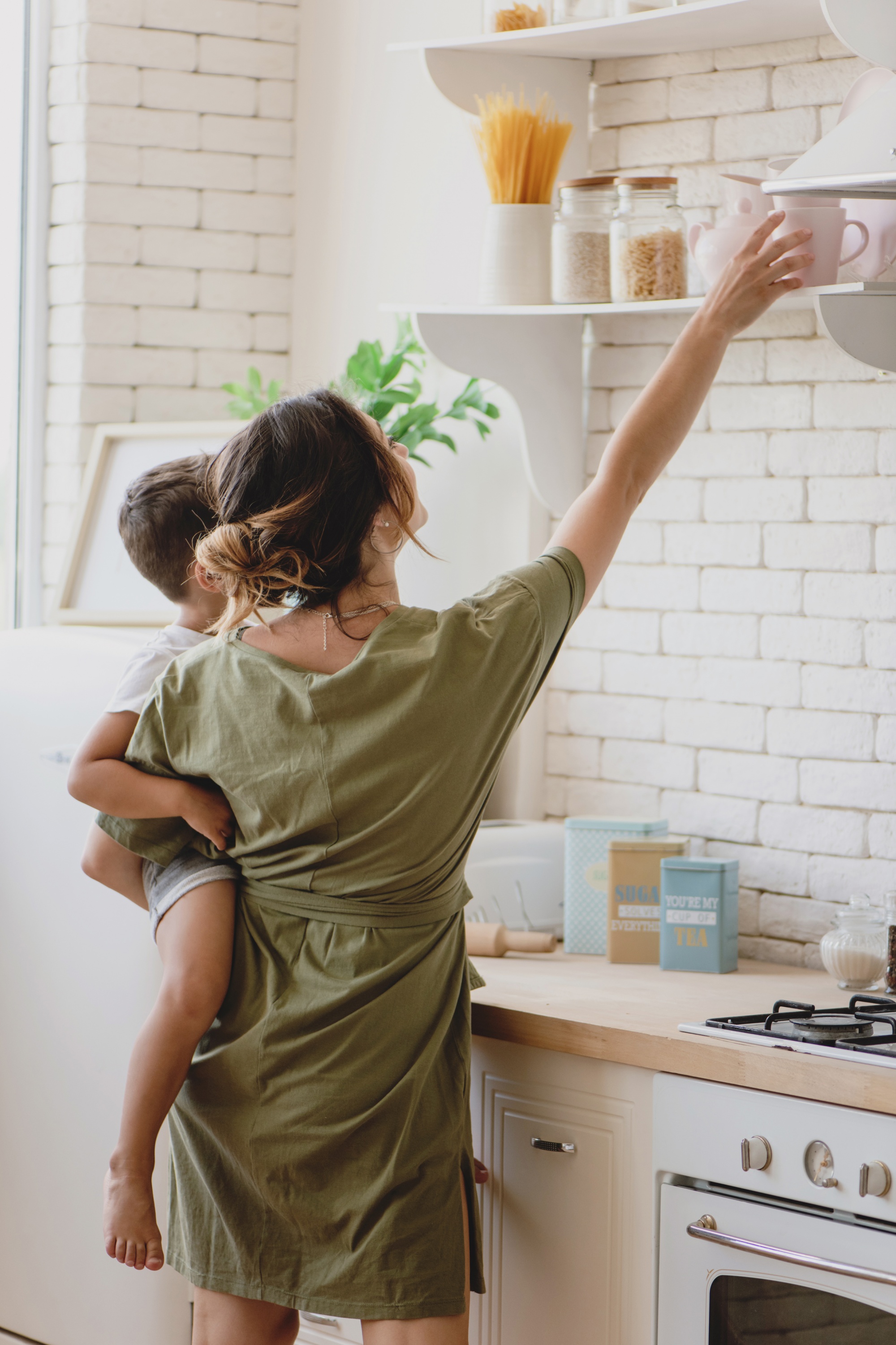 How To Style Pinterest-Worthy Floating Kitchen Shelves mom reaching lower shelf to grab a mug