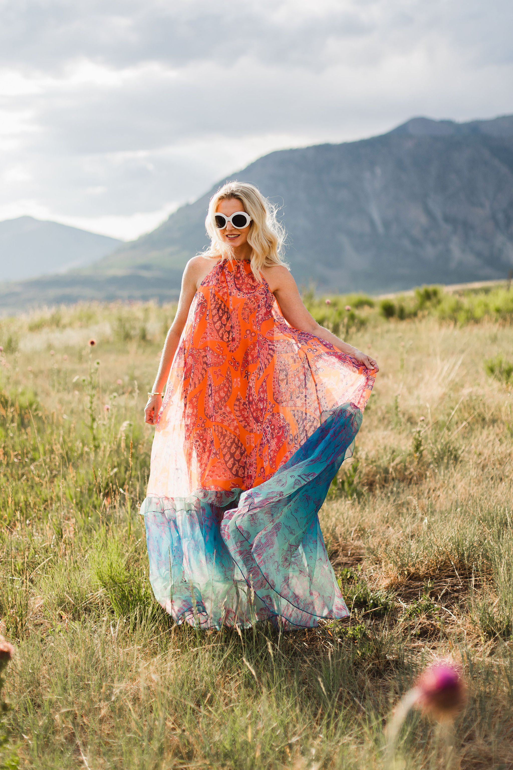 Ina dress by Staud in a tall grass field in the mountains of telluride featuring INA staud dress in orange and blue on fashion over 40 blogger Erin Busbee of Busbee Style