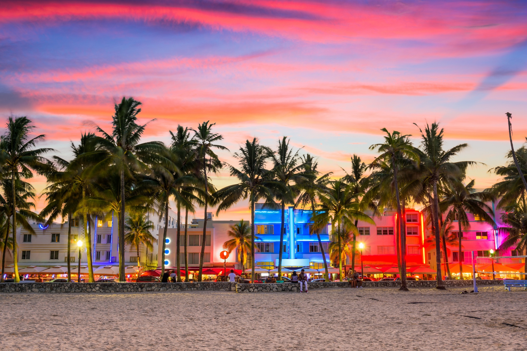 travel destinations for foodies, lit up hotels at sunset on Ocean Drive in Miami Beach, Florida