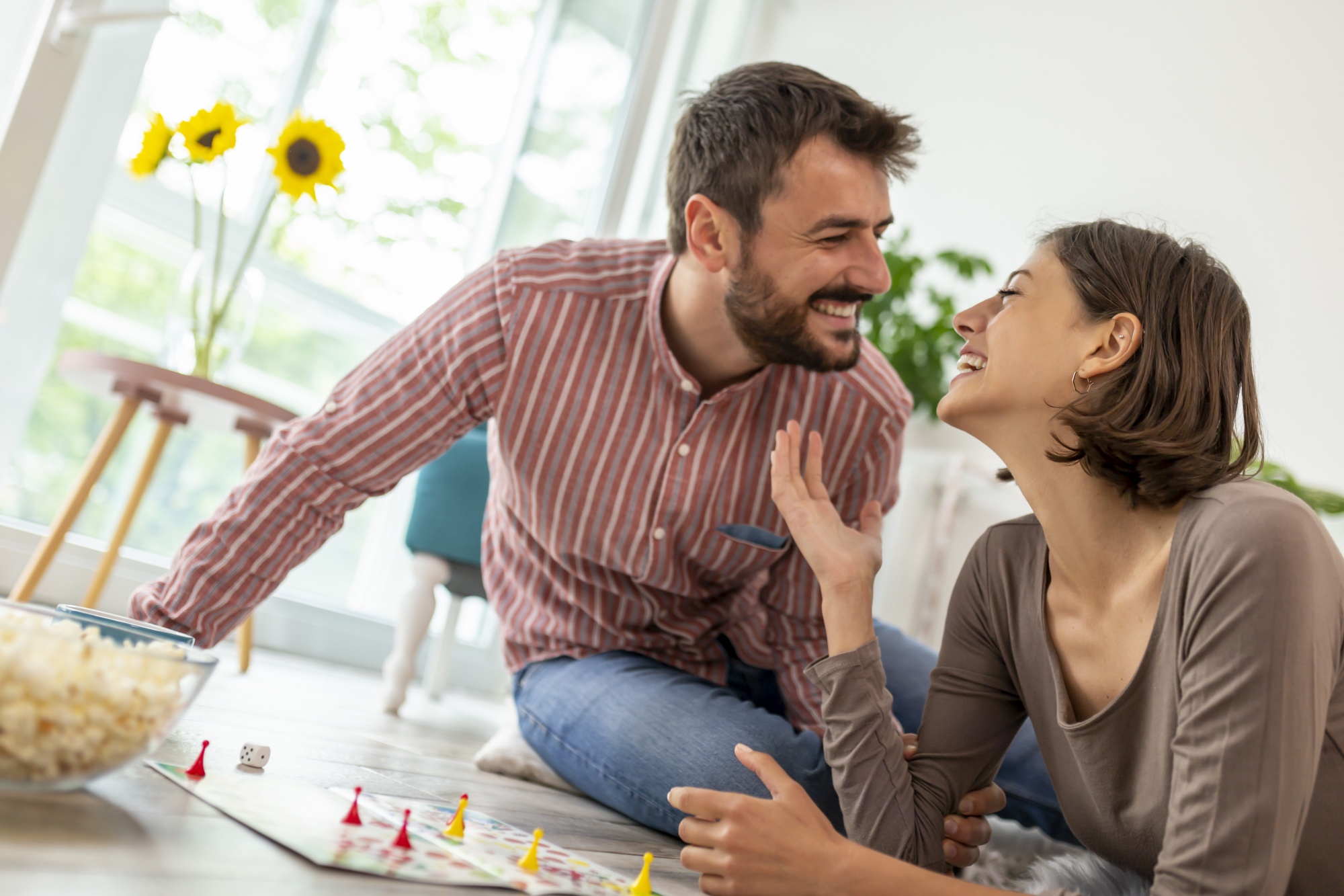 board games for date night, couple laughing having fun playing board game