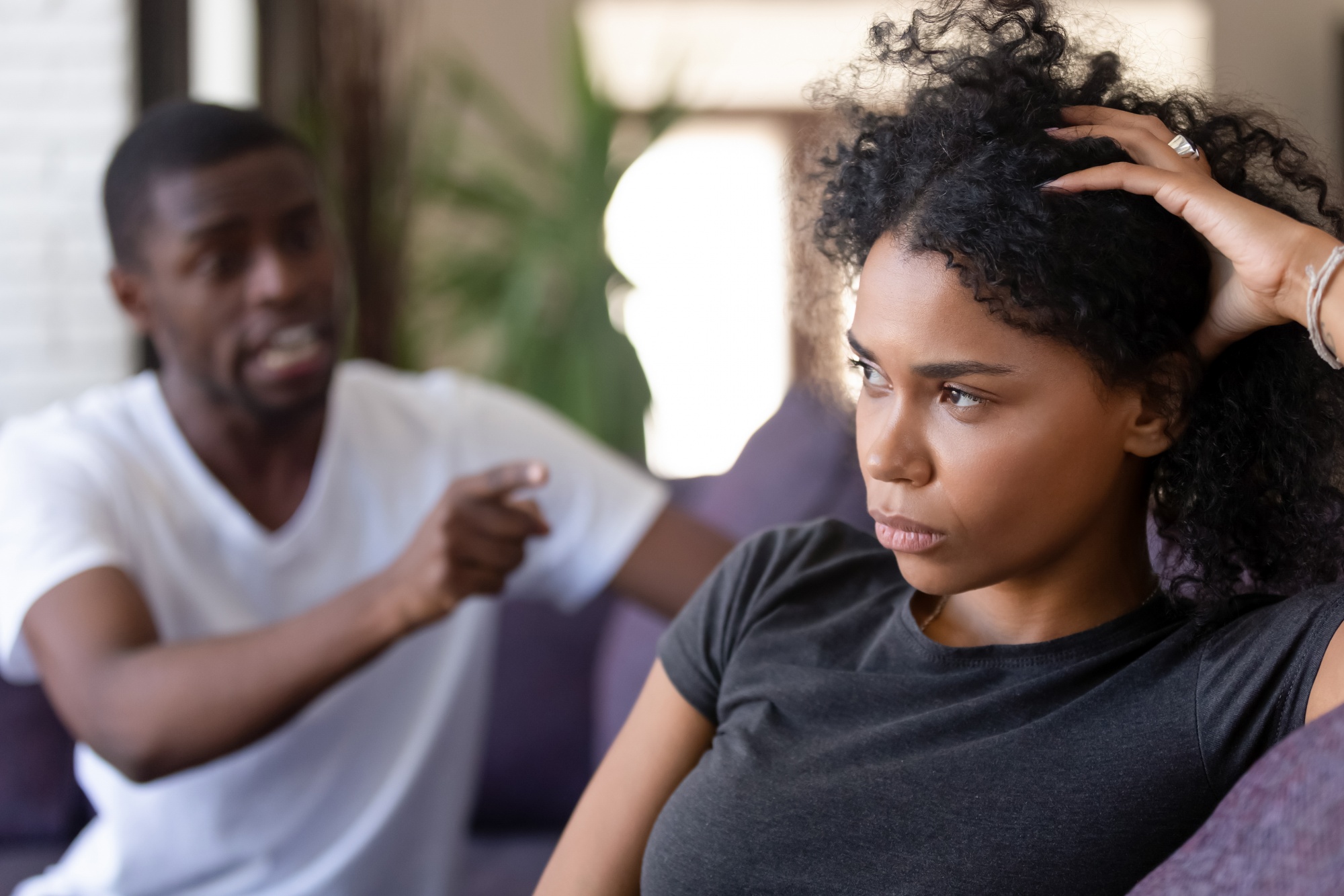 fighting fairly in your relationship, African American couple sitting on a sofa arguing