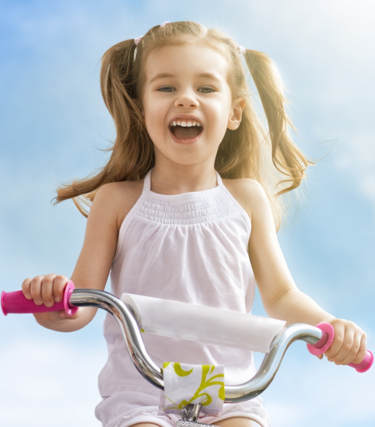 Essentials to Get Your Kids Outdoors, young girls riding her bicycle happy outdoors summer