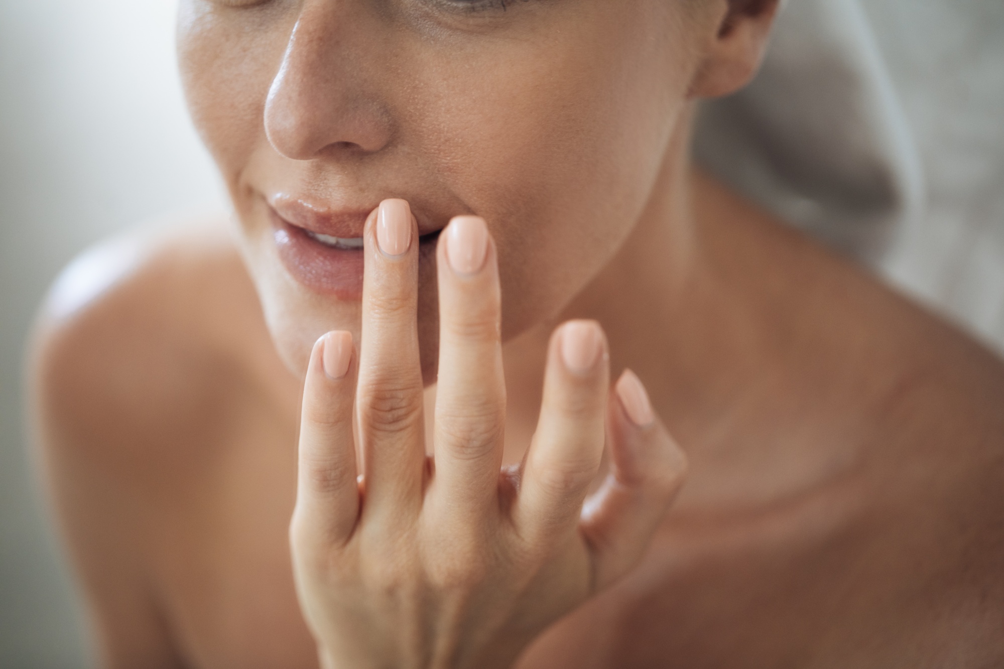 woman applying lip treatment fuller more youthful lips