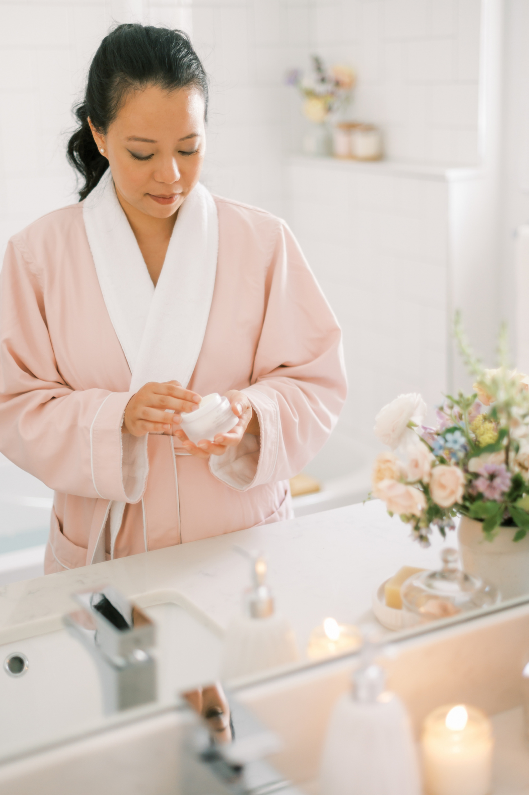 common menopause questions, Asian woman in pink robe applying cream
