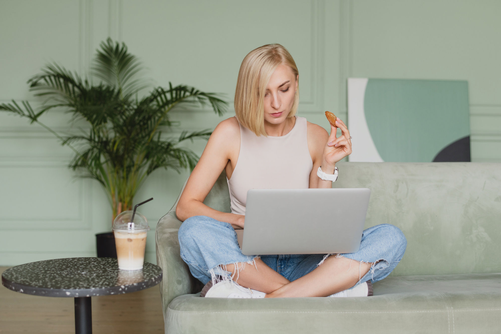 common menopause questions, Blonde woman with chin-length hair in denim cross-legged on couch