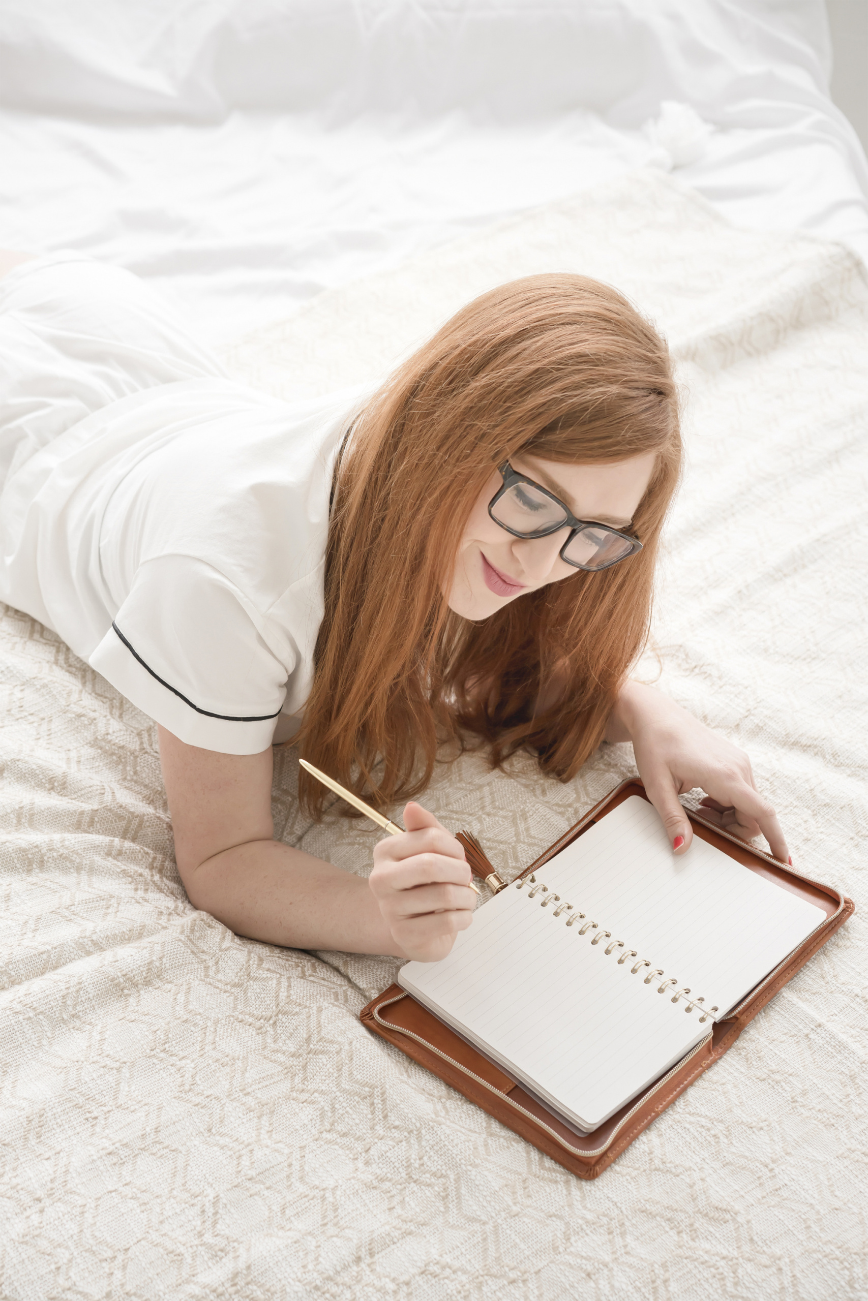 common menopause questions, Long auburn-haired woman journaling in bed