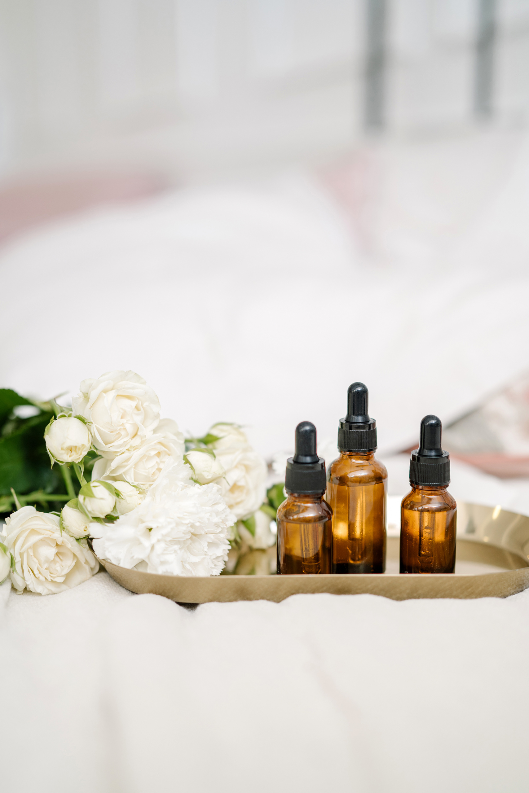 vitamin c serums, beauty tray with white flowers and serum bottles