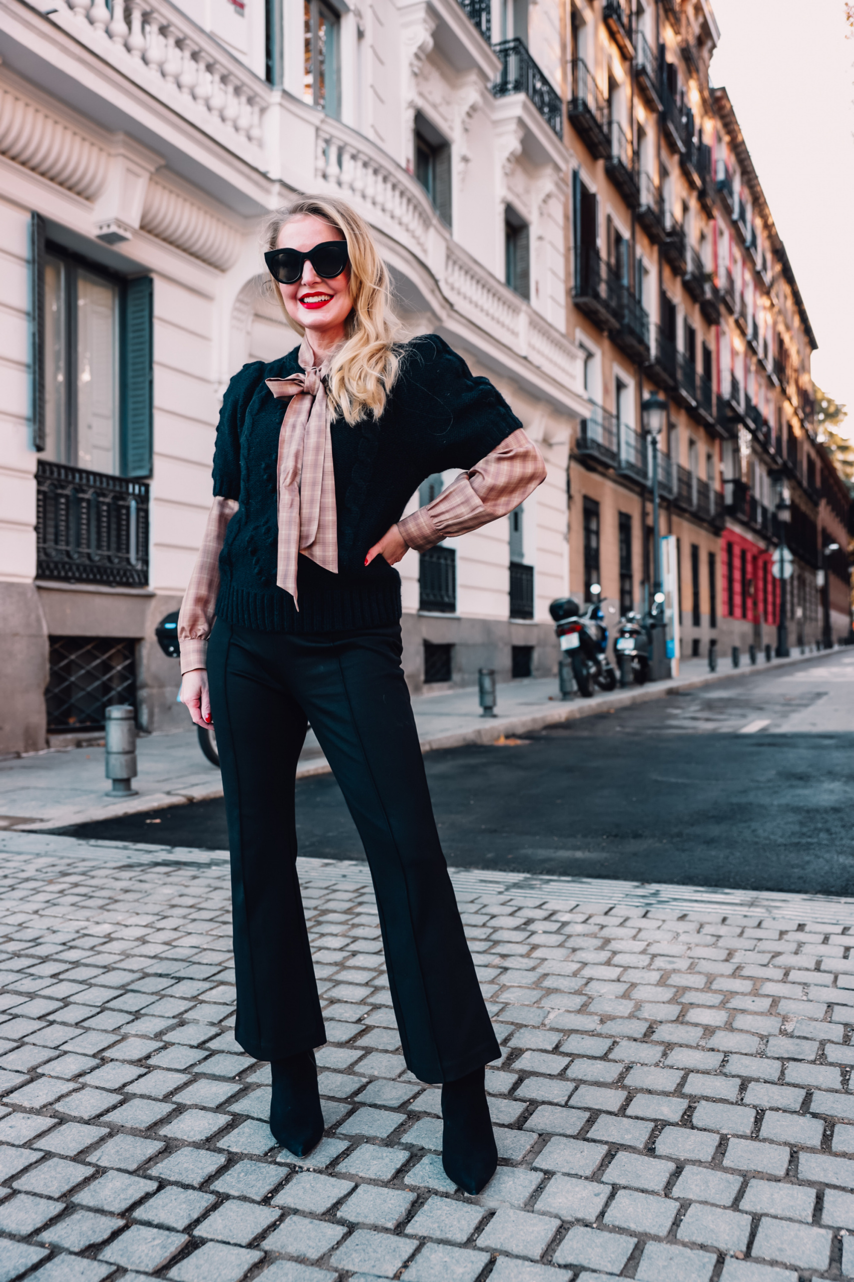how to wear plaid, plaid, ways to wear plaid, plaid outfit, plaid over 40, erin busbee, & other stories check tie neck blouse, & other stories bobble and cable knit puff sleeve sweater, black & other stories flare pants, black schutz bette booties, madrid, spain