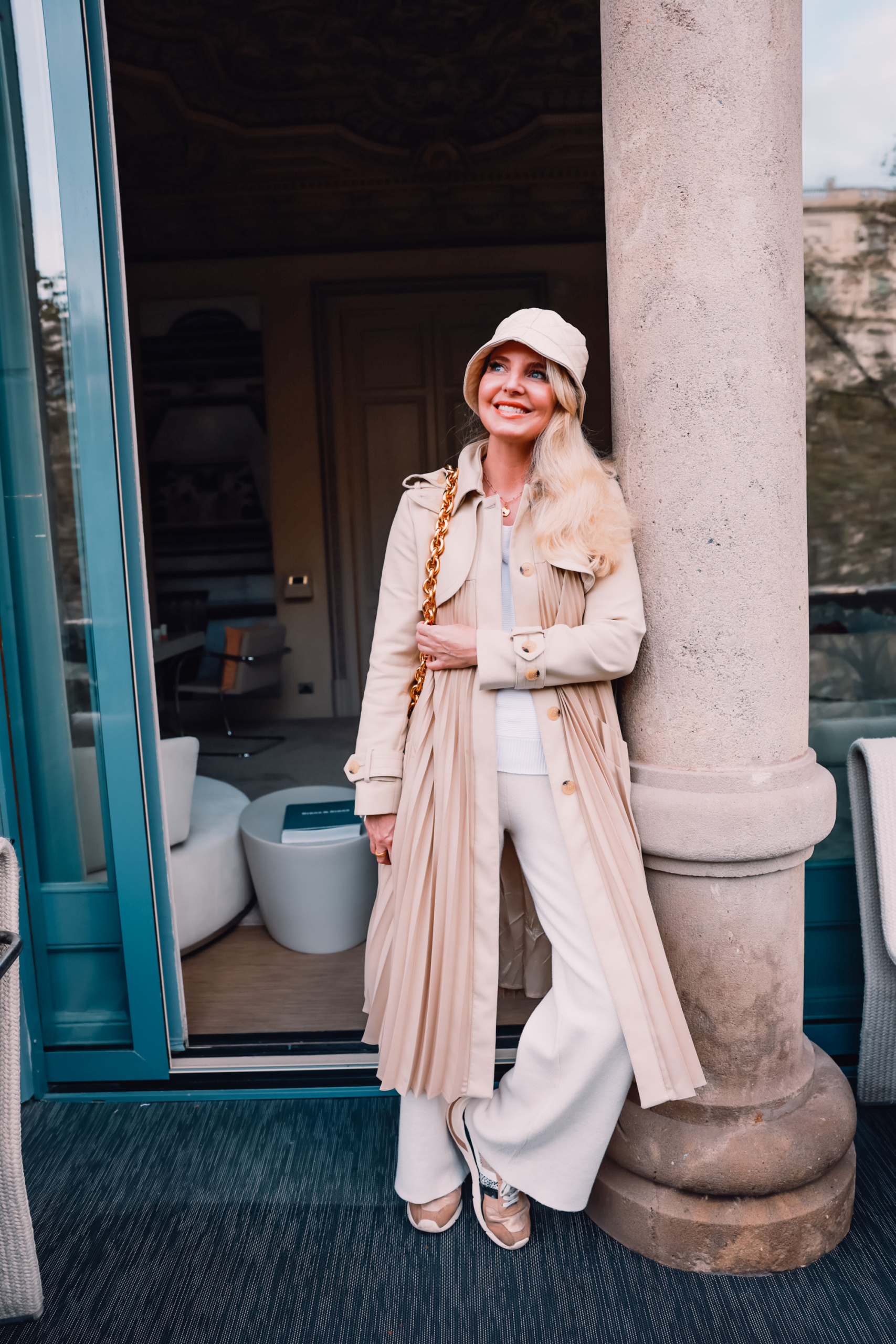 stylish loungewear, loungewear from couch to curb, how to transition loungewear, erin busbee, mango wide leg lounge pants, gola sneakers, white ribbed one shoulder sweater, mango quilted bucket hat, sandro trench, bottega veneta cassette bag, el palauet, barcelona, spain