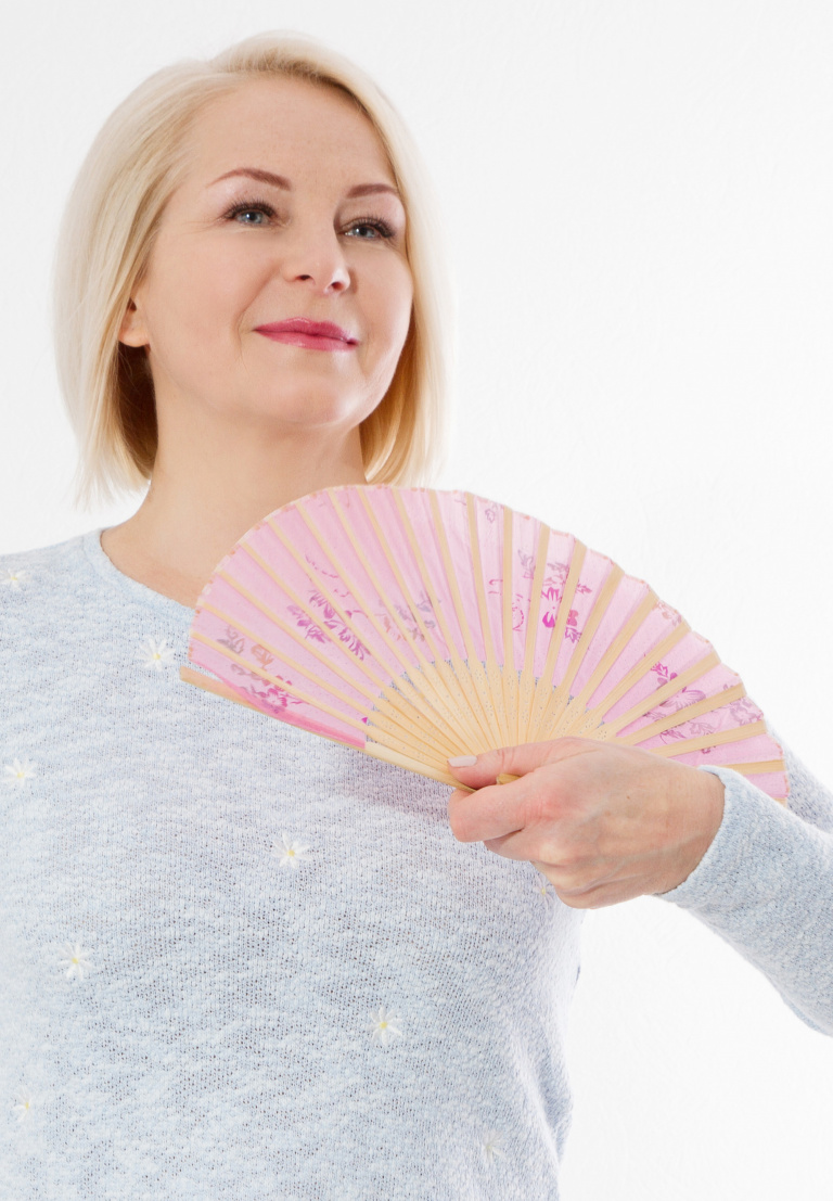 Makeup for Hot Flashes, happy middle aged woman with menopause holding a fan