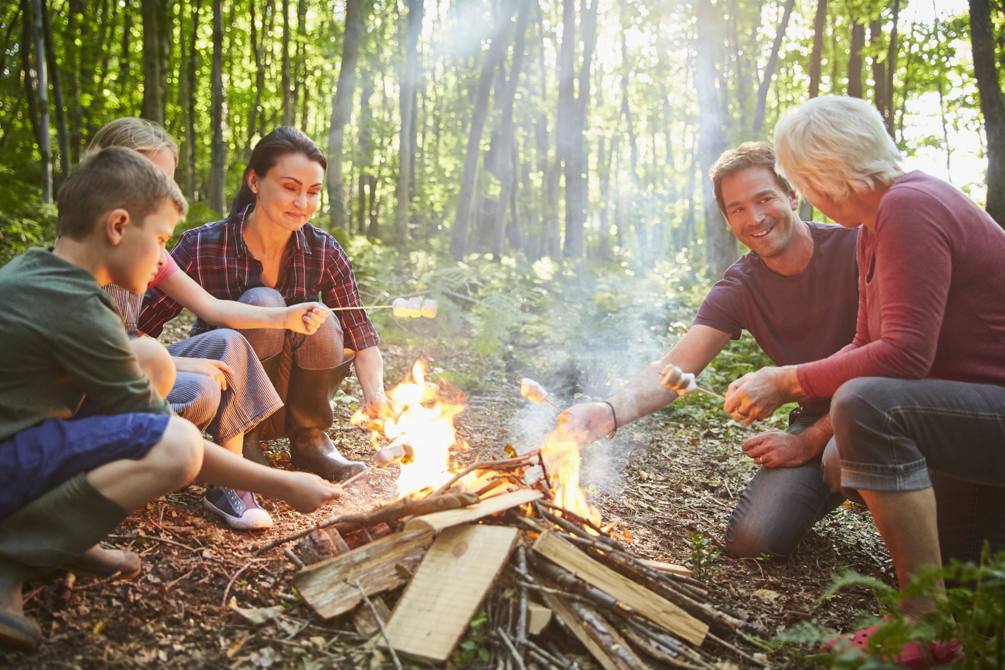 creative staycation ideas, multi-generational family camping roasting marshmallows