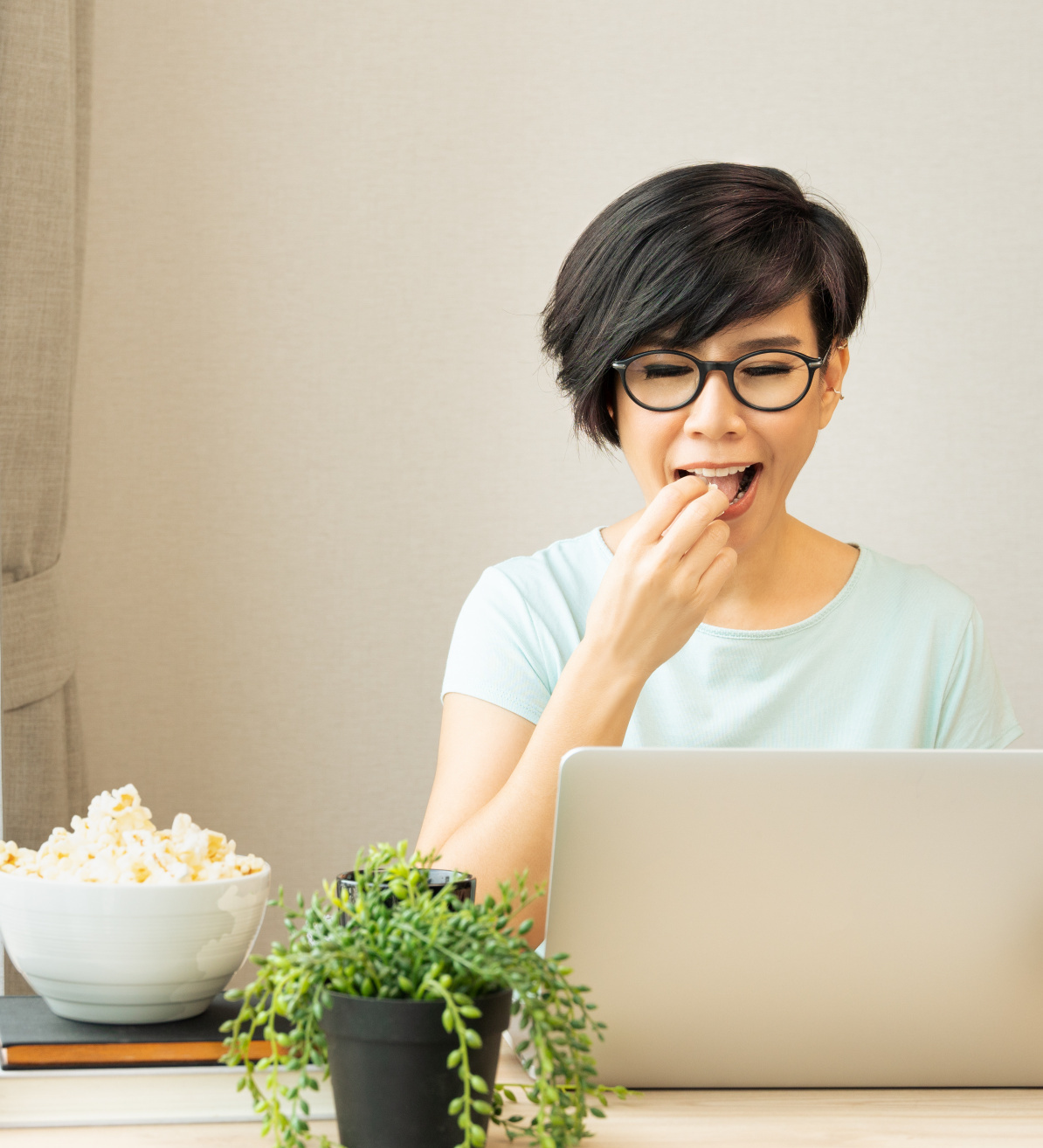 Healthy Snacks Woman eating popcorn while working