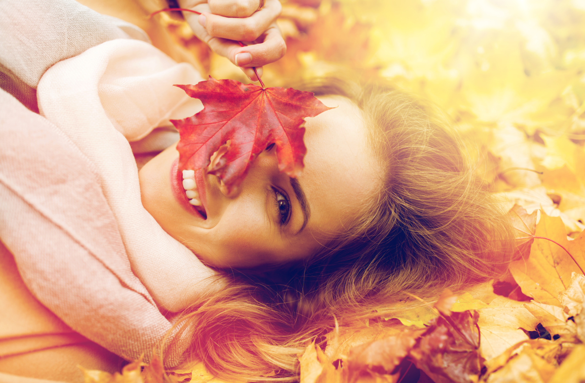 Beautiful happy woman lying on autumn leaves, fall skincare tips, fall skincare routine, taking care of your skin in the fall, transitioning skincare from summer to fall, Erin Busbee, Busbee Style, Beauty Over 40