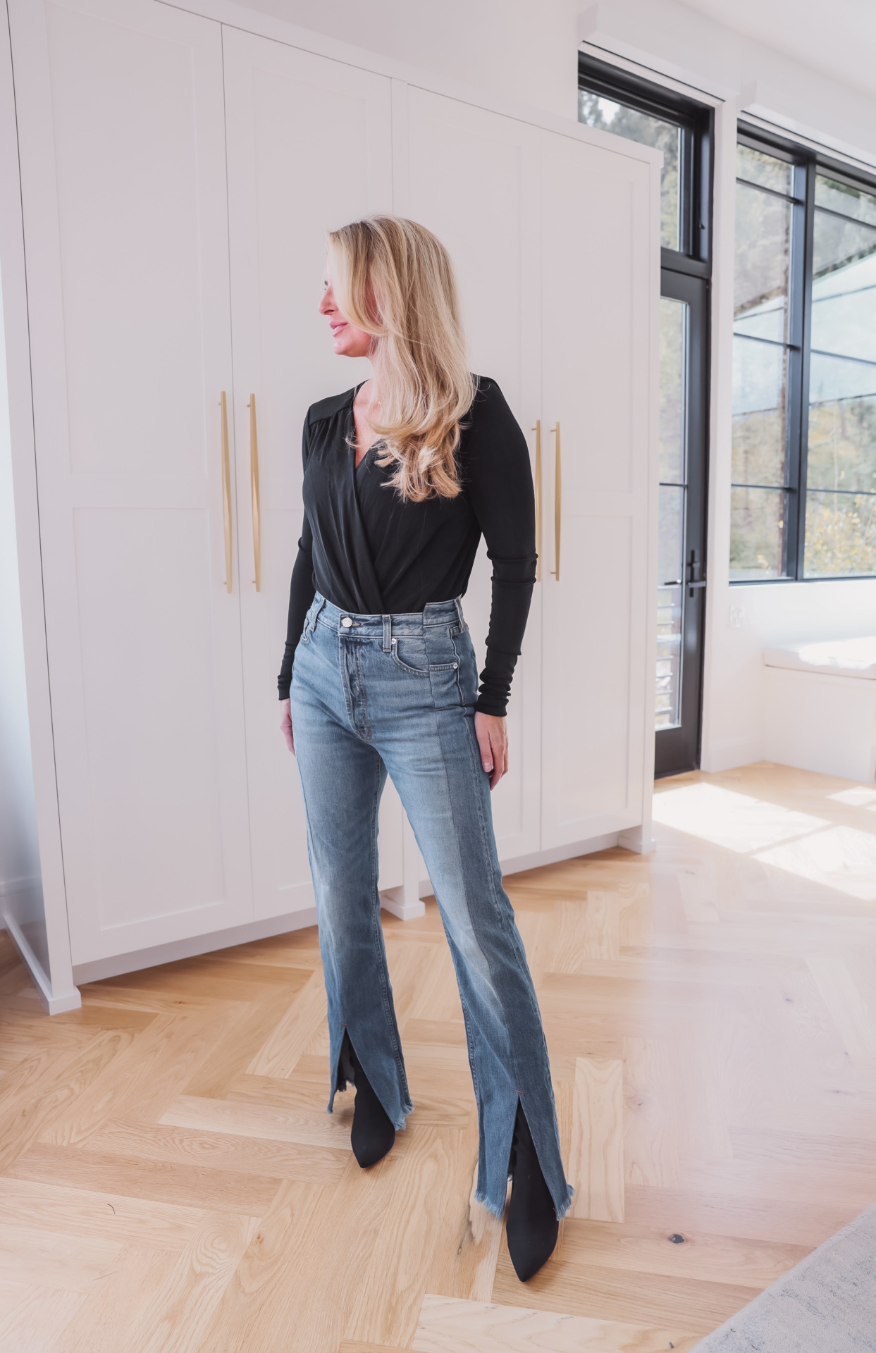 woman wearing Split seam jeans and black top for jean trends