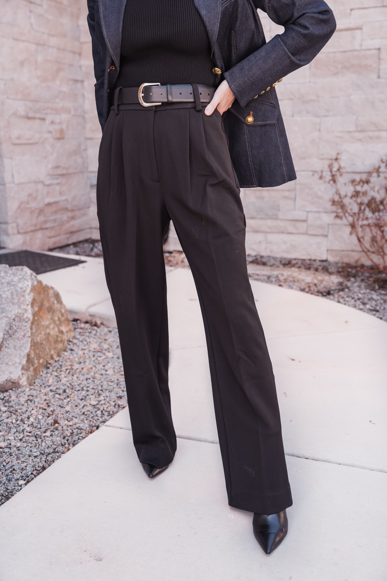 how to style wide leg pants: woman wearing black wide leg pants, black top and a jacket